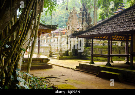 Steintor des Pura Kehen Tempels aus dem 13. Jahrhundert in Bali, Indonesien, zwischen Vegetation und holzbedeckten Terrassen. Stockfoto