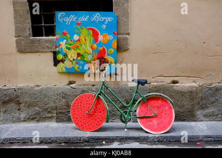 Fahrrad lehnte sich gegen die Wand mit Melone Wirkung Räder, Florenz, Italien Stockfoto