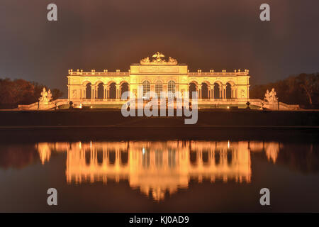 Die Gloriette in Schönbrunn Palace Gardens, Wien, Österreich in der Nacht als er im Wasser spiegelt. Stockfoto