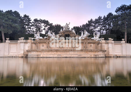 Neptunbrunnen von Schloss Schönbrunn in Wien, Österreich bei Sonnenuntergang. Stockfoto