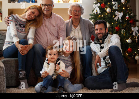 Familie an Heiligabend zusammen mit der Großmutter und Großvater genießen Stockfoto