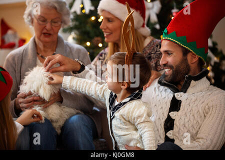 Familie zusammen für Weihnachten streicheln kleinen niedlichen Hund Stockfoto