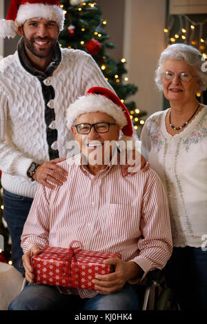 Älterer Mann mit Familie erhielt Weihnachtsgeschenk Stockfoto