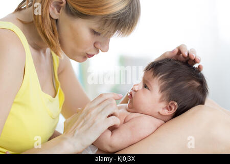 Seitenansicht der fürsorgliche Mutter und ihr Baby Baby an einander, Zeit gemeinsam zu Hause suchen Stockfoto