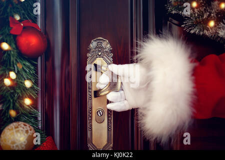 Santa claus behandschuhten Hände die Tür zu Öffnen Stockfoto