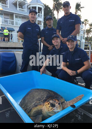 Mitglieder der Coast Guard Station Key West, hintere Reihe von links nach rechts, Feuerwehrmann Karl Paulsson, Seaman Edgar Lugo, Seaman Jake Lee, vordere Reihe von links nach rechts zu, Petty Officer 3. Klasse Joseph Zucker und Seaman Karlie Milliken einen Moment für ein Foto mit Drifter, ein 150-lbs-Karettschildkröte, bevor Sie es in die wild in der Nähe von Key West, Florida, Donnerstag, November 16, 2017 frei. Drifter war gerettet aus Angelschnur, die Teil der Sturm Schmutz wurde vom Hurrikan Irma und in der Turtle Hospital in Key West rehabilitiert. U.S. Coast Guard Foto von Ensign Karrie Jeffries Stockfoto