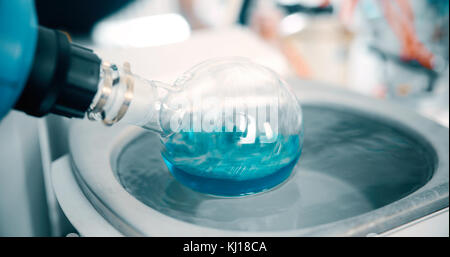 Mechanisches Rühren, Flüssigkeit der grünen Farbe gemischt in einer Runde Flasche. Stockfoto