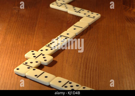 Lange Linie von Domino auf hölzernen Hintergrund Stockfoto