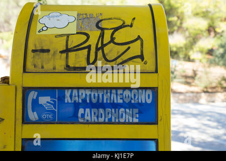 Nahaufnahme eines alten griechischen gelben Kartentelefons, in einer Straße im Zentrum von Athen. Stockfoto