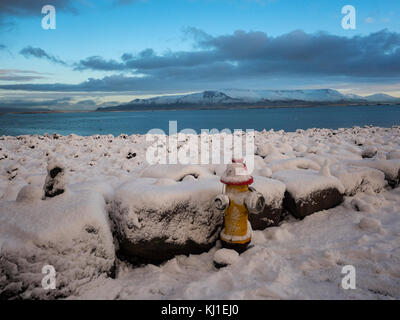 Land aus Feuer und Eis: jetzt auf einem Hydranten über eine verschneite Reykjavik Bucht, Island Stockfoto