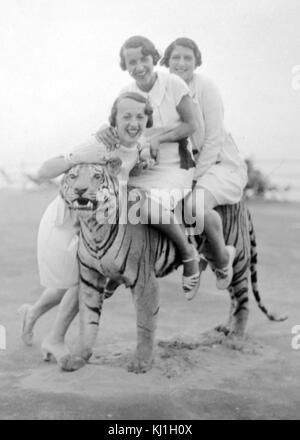 Britische Touristen sitzen auf einem ausgestopften Tiger im Urlaub in Italien, kurz vor dem Zweiten Weltkrieg. 1938 Stockfoto