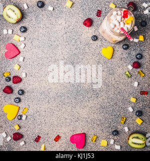 Verschiedene Beeren, Marmelade und Marshmallow gesäumt Rahmen auf Granit Hintergrund mit frischem Obst, Smoothies, Valentinstag, Ansicht von oben Platz für Text Stockfoto