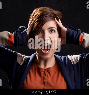 Frau schreien mit den Händen auf den Kopf Stockfoto