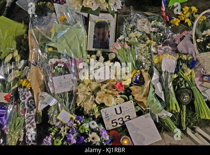 Blumen und Tribute schmücken ein Porträt des ermordeten Polizisten, PC Keith Palmer,, im Parlament grün gegenüber dem britischen Parlament in London, nach dem 21. März 2017, terroristische Angriffe auf die Westminster Bridge, und das Parlament. Der Angreifer fuhr ein Fahrzeug in die Fußgänger auf die Westminster Bridge und einer Masse von Menschen in der Nähe von Stockfoto