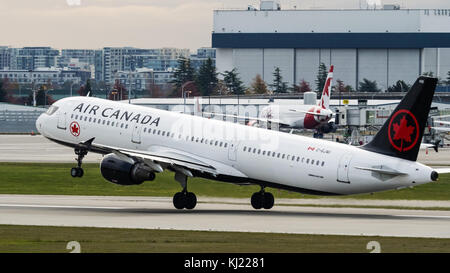 Richmond, British Columbia, Kanada. November 2017. Ein Air Canada Airbus A321-200 (C-GJWI), ein einschiffiges, schmales Jet-Linienflugzeug, das in der neuen Lackierung der Airline lackiert ist, startet vom Vancouver International Airport. Im Hintergrund: Ein Air Canada Rouge Boeing 767-300ER Jetliner. Quelle: Bayne Stanley/ZUMA Wire/Alamy Live News Stockfoto