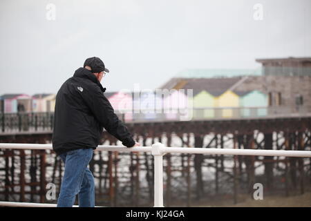 Hastings, East Sussex, UK. 21. November 2017. Älterer Mann überlegt, wie er sie an der Hastings Pier an einem windigen, aber hell und sonnig aussieht. Foto: Paul Lawrenson/Alamy leben Nachrichten Stockfoto