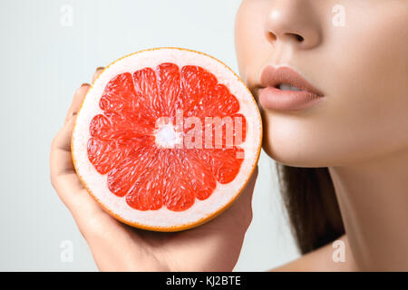 Hübsche Frau mit köstlichen Pampelmuse in ihre Arme. Stockfoto