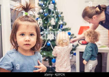Niedliche Kind auf dem Hintergrund der Familie verzieren christms Baum in Home Stockfoto