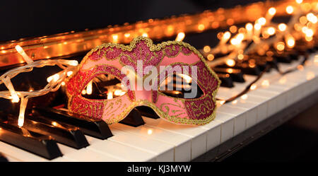 Karneval Maske und Lichter auf ein klassisches Piano Tastatur Stockfoto