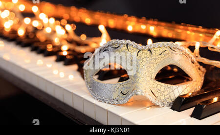 Karneval Maske und Lichter auf ein klassisches Piano Tastatur Stockfoto