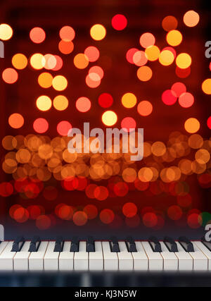 Klassisches Piano keyboard Vorderansicht auf Weihnachtsbeleuchtung bokeh Hintergrund Stockfoto