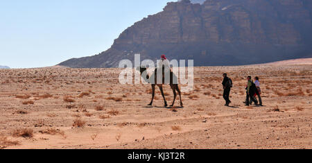 Wadi Rum, Jordanien - Januar 5, 2009: Touristen und ein Kamel guide Fahrt durch Wadi Rum auch als das Tal des Mondes bekannt. Stockfoto