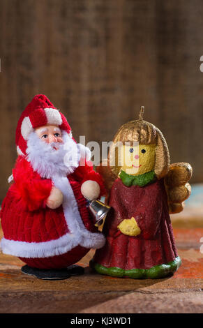 Weihnachtsdekoration, bunte Engel Mädchen Kerzenlicht und Weihnachtsmann in rot Close up Kopie Raum Stockfoto