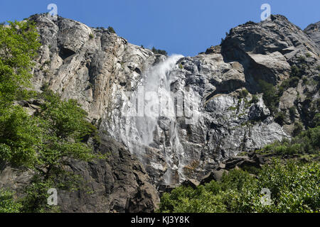 Bridalveil fällt, wie es im Wind in Yosemite National Park durchgebrannt ist. Es ist eine der bekanntesten Wasserfälle im Yosemite Valley in Kalifornien Stockfoto