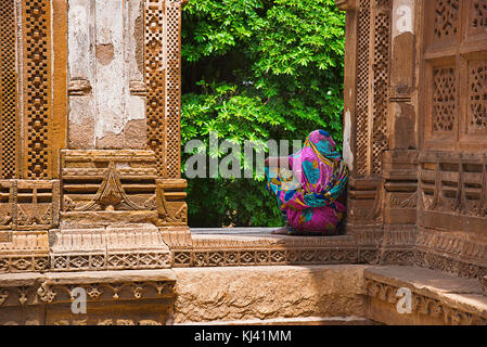 Eine Frau sitzt auf der geschnitzten Wand einer großen Kuppel über einem Podium gebaut, Jami Masjid (Moschee), UNESCO-geschützten Champaner - Pavagadh Archäologische Par Stockfoto