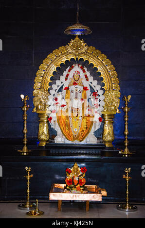 Lord Ganesh weißes Marmoridol mit dekorativem Messingprabhaval und vier traditionellen Lampen. Pranav Ganesh Mandir, Pune, Maharashtra, Indien Stockfoto