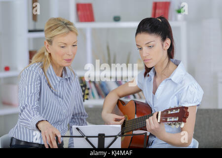 Lady Musik professor Gitarre unterrichten zu ihren jungen Studenten Stockfoto