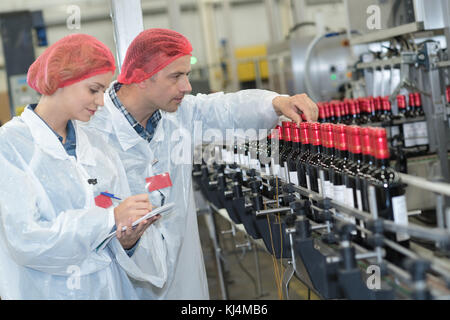 Fabrikarbeiter, die Flaschen Stockfoto