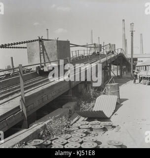 1950, historisches Bild, das die Rohstoffe für die Ziegelherstellung zeigt - oxford Clay -, die in Karren entlang einer Eisenbahnstrecke zurück in die Ziegelei in Stewartby, Bedfordshire, England, Großbritannien, transportiert werden. Damals war Stewartby die größte Ziegelei der Welt und gehörte der London Brick Company, einem Unternehmen, das zu einem führenden Beispiel für den "moralischen Kapitalismus" wurde, das von namhaften Philanthropen geführt wurde, der Familie Stewart, die in Stewartby ein "Modelldorf" baute. Stockfoto