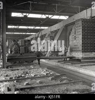 In den 1950er Jahren wurden Arbeiter in einem der riesigen Öfen, in denen die Steine gefeuert und fertig gestellt wurden, in Stewartby, Bedfordshire, dem damals größten Ziegelwerk der Welt, das der London Brick Company gehörte. Stockfoto