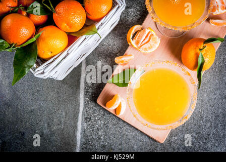 Rezepte und Ideen von winter Fruchtcocktails, Tangerine martini Margarita mit frischen Mandarinen im Korb, auf dunklem Hintergrund, kopieren Raum Stockfoto