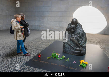 Deutschland Tourismus, Touristen sehen das Mutter-Sohn-Denkmal in der Nationalen Gedenkstätte für die Opfer von Krieg und Tyrannei, Neue Wache, Berlin, Deutschland Stockfoto