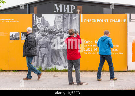 Berliner Mauer Museum, Touristen Blick auf einer fotografischen Darstellung auf der Wand des Mauermuseum an der Friedrichstraße, in der Nähe von Checkpoint Charlie, Berlin. Stockfoto