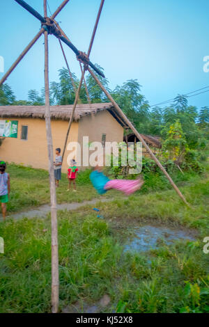 Chitwan, Nepal - November 03, 2017: Nicht identifizierte Kinder spielen in der Nähe von Holzhäusern in Chitwan gebaut, Nepal Stockfoto