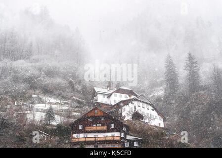 Winterlandschaft mit einem dichten Schneefall über ein österreichisches Dorf, Hallstatt, gelegen auf dem Dachsteinmassiv, einer der Welterbestätten in Österreich. Stockfoto