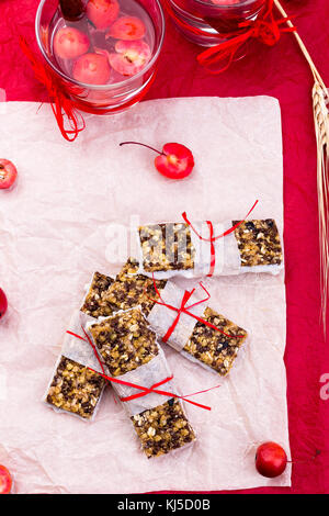 Diät Müsliriegel mit detox Apfel-zimt Wasser auf rote Paprika und Holz- Hintergrund. top anzeigen. Flach Stockfoto