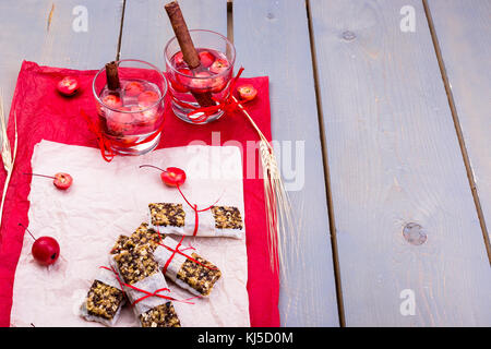Diät Müsliriegel mit detox Apfel-zimt Wasser auf rote Paprika und Holz- Hintergrund Stockfoto