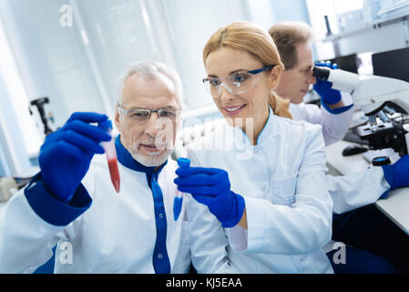 Inspiriert medizinische Arbeiter holding Reagenzgläser Stockfoto