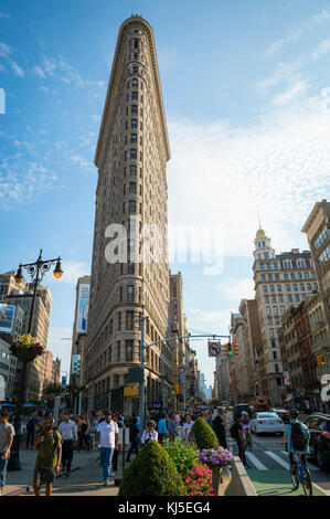 NEW YORK - 11. AUGUST 2017: Verkehr und Fußgänger passieren den Broadway am Flatiron Building, einem der ersten und berühmtesten Wolkenkratzer der Stadt. Stockfoto