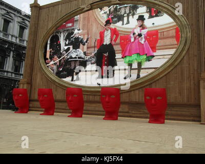 Großer Bildschirm mit Richtern Podien in Form von roten Masken im Karneval von Venedig (Carnevale di Venezia), ein jährliches Festival in Venedig, Italien, statt. Ein Sieg der 'Serenissima Repubblica auf "Recall gegen den Patriarchen von Aquileia, im Jahr 1162. In die Ehre dieses Sieges, die Leute begannen zu tanzen und in San Marco Platz versammeln. Stockfoto