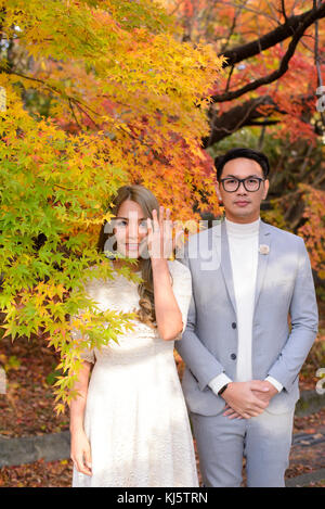 Junge japanische Paare zeigen ihr Engagement Ring im Herbst Park Stockfoto