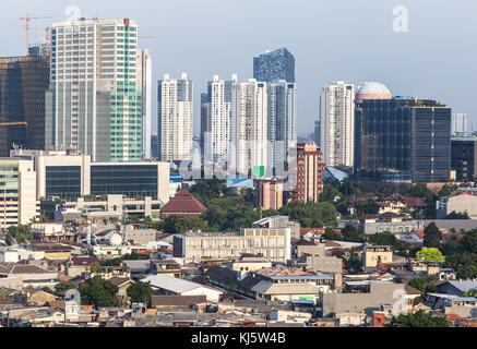 Luftaufnahme von ein flaches Wohnviertel im Kontrast zu modernen Eigentumswohnung und Bürotürme im Herzen von Jakarta, Indonesien Hauptstadt. Stockfoto