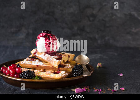 Gebackene traditionelle belgische Waffeln mit Eis und Berry Fruchtsauce, selektiver Fokus und Leerzeichen Stockfoto