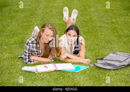 Tennage Studenten auf den Rasen und die Studie zusammen liegen Stockfoto