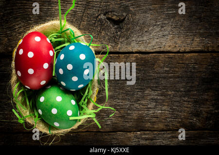 Östlichen Eier im Korb auf hölzernen Hintergrund punktiert. Selektive konzentrieren sich auf die Eier. Stockfoto