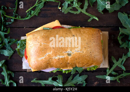 Focaccia sandwich gefüllt mit Schinken und Käse auf hölzernen Hintergrund von oben, selektiver Fokus Stockfoto